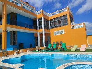 a house with a swimming pool in front of a building at Residencial oliveira in Porto Novo