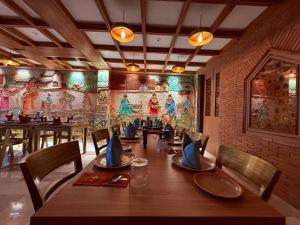 a dining room with a long table and chairs at Ikonic Hotel - Bhushi Dam Lonavala in Lonavala