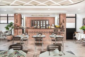 ジャカレイーにあるHotel Marmoのテーブルと椅子とバーのあるレストラン