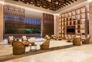 Hotel Irotama Bungalows & Bohios في سانتا مارتا: ردهة مع كراسي من الخيزران وجهاز تلفزيون في المبنى