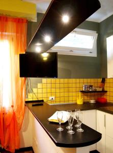 a kitchen with three wine glasses on a counter at Happy Home BO Fiera Self Check-in in Bologna