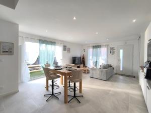 een keuken en woonkamer met een tafel en stoelen bij L'Océan - Ambiance Apaisante & Rafraichissante in Biville-sur-Mer