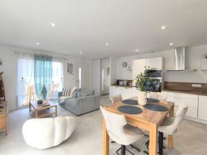 een keuken en woonkamer met een houten tafel en stoelen bij L'Océan - Ambiance Apaisante & Rafraichissante in Biville-sur-Mer