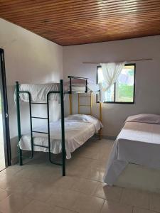 a bedroom with two bunk beds and a window at Cabaña la Hamaca Grande un encuentro con la naturaleza in El Zaino