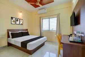 MuthugadahalliにあるHotel O Airport Nestのベッドと机とテレビのある寝室