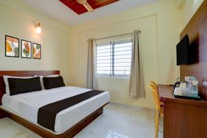 MuthugadahalliにあるHotel O Airport Nestのベッドと机とテレビのある寝室