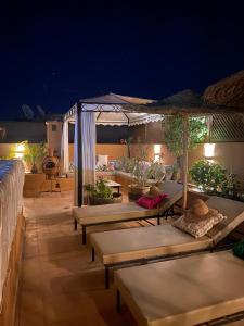 un patio con tavoli e ombrelloni di notte di Riad le Voile d'Orient a Marrakech