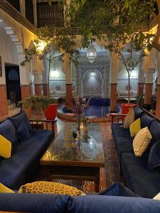 un soggiorno con divani blu e un tavolo di Riad le Voile d'Orient a Marrakech