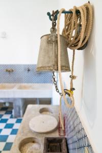 a bell hanging on a wall next to a sink at Villa Maresole in Favignana +23 photos