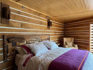 a bedroom with a bed and a wooden wall at Hotel Boutique La Casa de Coco in Gorbea
