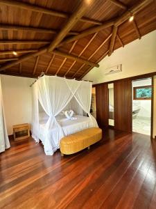 a bedroom with a bed with a mosquito net at Casa no Condomínio Aguas d'Ajuda in Porto Seguro +39 photos