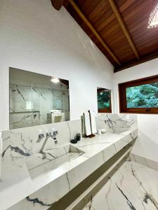 a bathroom with two sinks and a large mirror at Casa no Condomínio Aguas d'Ajuda in Porto Seguro