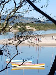 een groep mensen die op een strand lopen naast een waterlichaam bij Pousada Guarda do Embaú in Guarda do Embaú +33 foto's