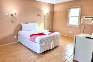 a bedroom with a bed with a red blanket on it at Skylark Motel by OYO in Bedford +16 photos