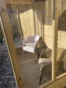 Garden Room at Tartan House في إينفيرنيس: شاشة في الشرفة مع كرسي وأريكة