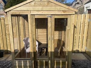 Garden Room at Tartan House في إينفيرنيس: بيت زجاجي خشبي بداخله كرسي