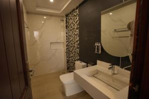 a bathroom with a sink and a toilet and a mirror at Rashha Suites Jhika Gali Murree in Murree +55 photos