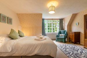 a bedroom with a bed and a chair and a window at Alderfen View by Leap Escapes in Worstead +30 photos