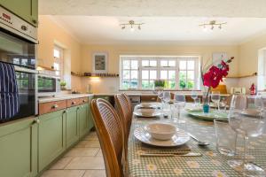 a kitchen with a table and chairs in a kitchen at Alderfen View by Leap Escapes in Worstead