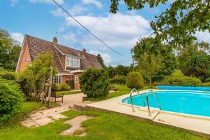 a house with a swimming pool in the yard at Alderfen View by Leap Escapes in Worstead