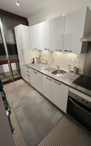 a kitchen with white cabinets and a sink at Trocadero in Paris