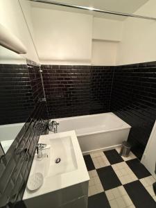 a bathroom with a white sink and a bath tub at Trocadero in Paris