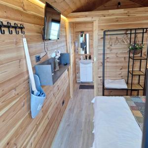 a bedroom in a tiny house with a bed and a sink at Casute La Struti in Tîrgu Neamţ