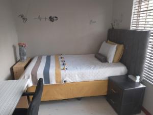 een kleine slaapkamer met een bed met een houten hoofdeinde bij Nested at L&MX in Centurion