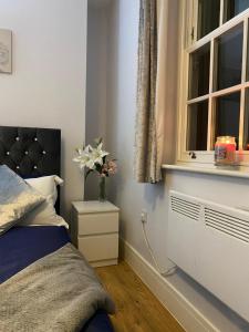 Luxury home from home 2 في ميدستون: غرفة نوم بسرير ونافذة وزهرية بها ورد +16 صورة