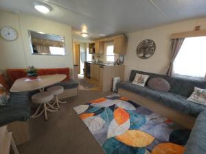 a living room with a couch and a table at The Retreat Finch - Marine Holiday Park in Rhyl