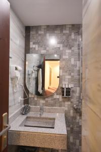 Rashha Suites Jhika Gali Murree في مورى: حمام مزود بحوض ومِرآة +48 صورة