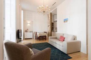 a living room with a white couch and a table at Casa Largo de Santo Antonio da Sé 8 in Lisbon