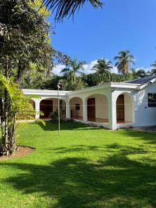 una casa bianca con un prato verde davanti di Villa Louana a Las Terrenas