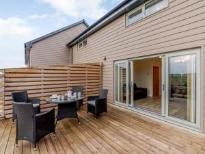 2 Bed in Alnwick oc-80488 في نيوتون باي ذا سي: فناء على طاولة وكراسي على سطح خشبي