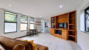 ein Wohnzimmer mit Couch und ein Esszimmer in der Unterkunft Cosme Velho: Luxo e Piscina para 8 Pessoas in Rio de Janeiro