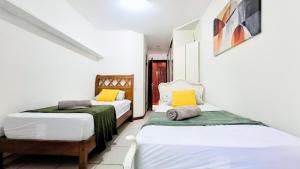 zwei Betten in einem Zimmer mit weißen Wänden in der Unterkunft Cosme Velho: Luxo e Piscina para 8 Pessoas in Rio de Janeiro + 185 Fotos