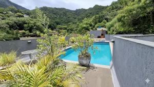 ein Schwimmbad in einem Haus mit Bergen im Hintergrund in der Unterkunft Cosme Velho: Luxo e Piscina para 8 Pessoas in Rio de Janeiro