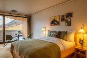a bedroom with a bed with a view of a mountain at La Senda Smart Hotel Zuoz in Zuoz