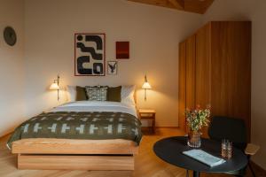 a bedroom with a large bed and a table at La Senda Smart Hotel Zuoz in Zuoz