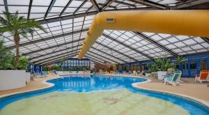 a large swimming pool with a slide in a building at The Retreat Finch - Marine Holiday Park in Rhyl