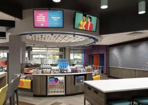 Tru By Hilton Puebla Angelopolis في بوبلا: مطعم للوجبات السريعة مزود بشاشتين على الحائط +صورة واحدة