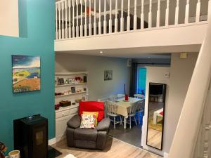 a living room with a table and a staircase at Cottage 33 Old Killarney Village Killarney V93K66X 4 King Beds Sleeps 8 Sharing in Killarney