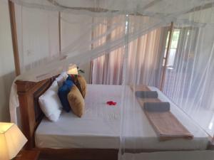 Villa Lanka Rose في Maggona West: غرفة نوم مع سرير مع دمية دب عليها