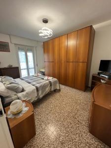 Airb&b Mery Milano-Cortina في ميلانو: غرفة نوم بها سريرين وتلفزيون وخزائن