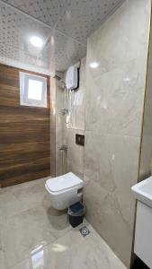 a bathroom with a white toilet and a shower at Aljari otel in Mezitli