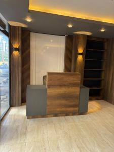 a lobby with a wooden counter and a window at Aljari otel in Mezitli