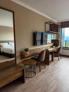 Un dormitorio con una cama, un escritorio y un espejo. en Mountain Sky Hotel, 