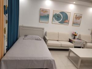 ein Schlafzimmer mit einem Bett und einer Couch in der Unterkunft Jianjia Homestay in Zhengzhou