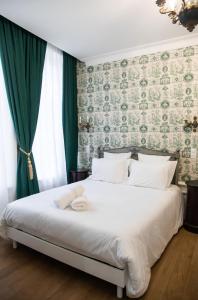 a bedroom with a white bed with a green wall at Maison la Louise in Ligny-en-Barrois +26 photos