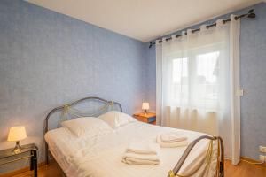 a bedroom with a bed with towels on it at Ma Vie'La - Swimming Pool - Balneo - Jacuzzi - Sauna in Rhinau